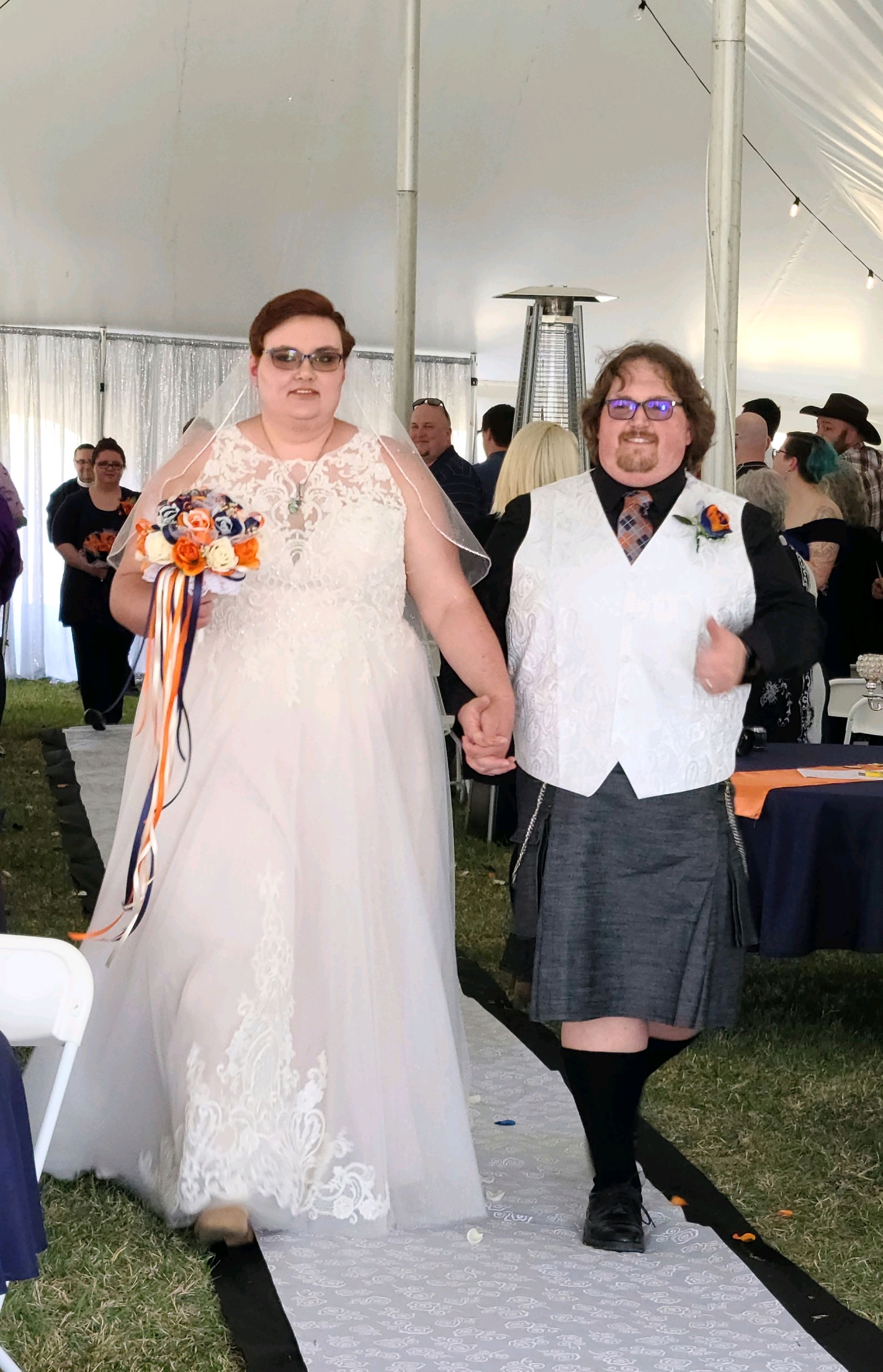 Derek and Elizabeth walking down the aisle together, Derek giving a thumbs up.